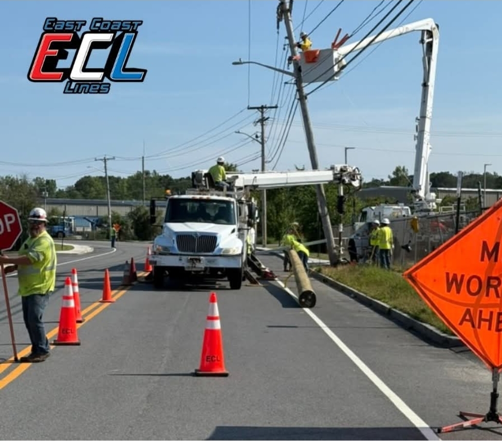 East Coast ECL Lines crew replacing a utility pole with cones and a work-ahead sign